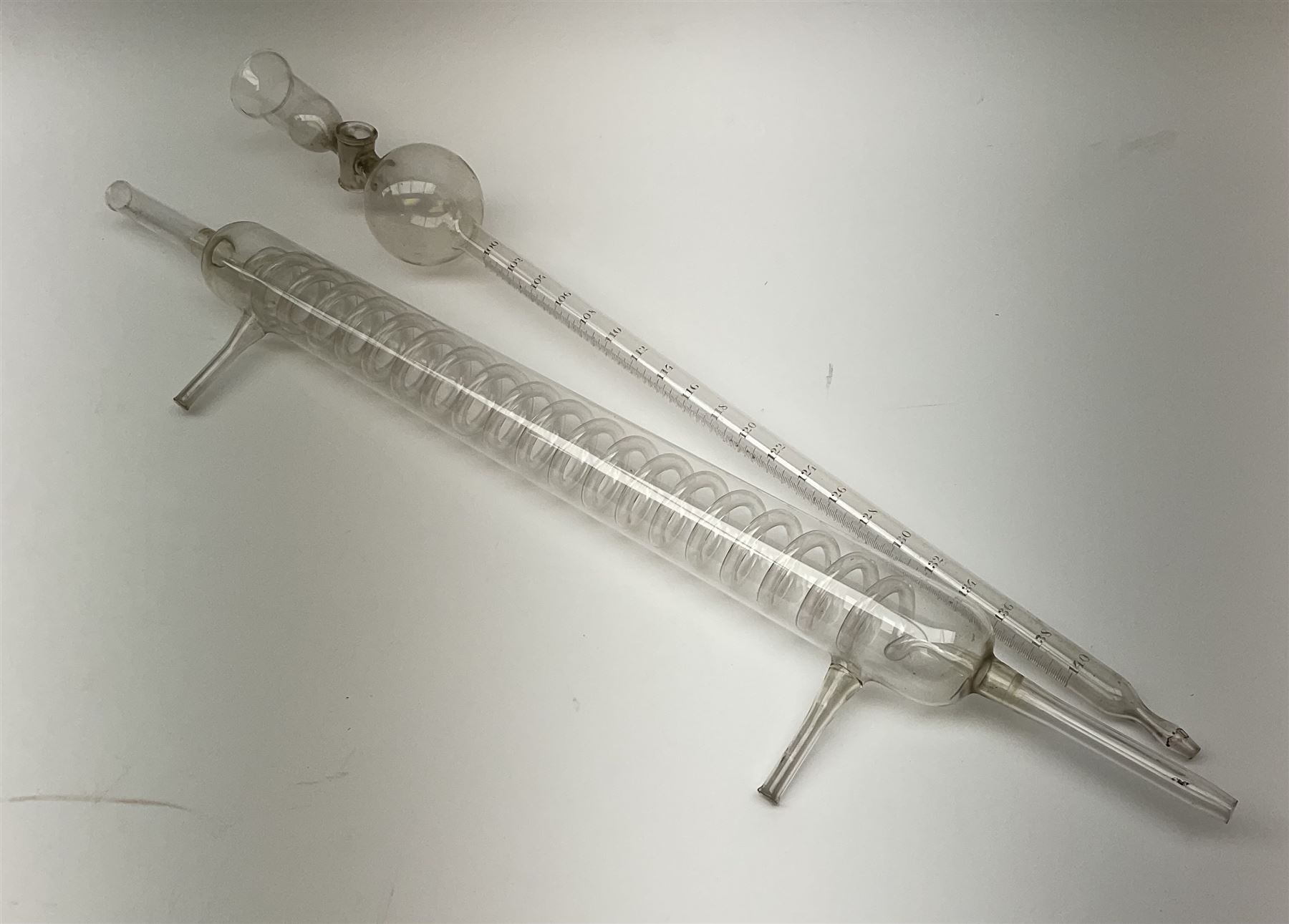 Collection of 19th century and later pharmaceutical laboratory glass, to include, large filter funnel, graham condenser, conical flask, bell jar and another with graduated tube, Provenance: discovered in the storeroom of a long established Hull pharmacist and opticians