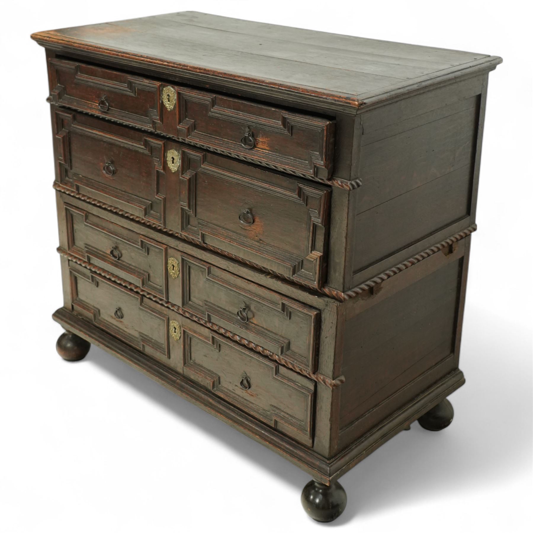 Late 17th-century oak chest, rectangular top above four graduated drawers with geometric panel mouldings, in two sections, supported on bun feet 