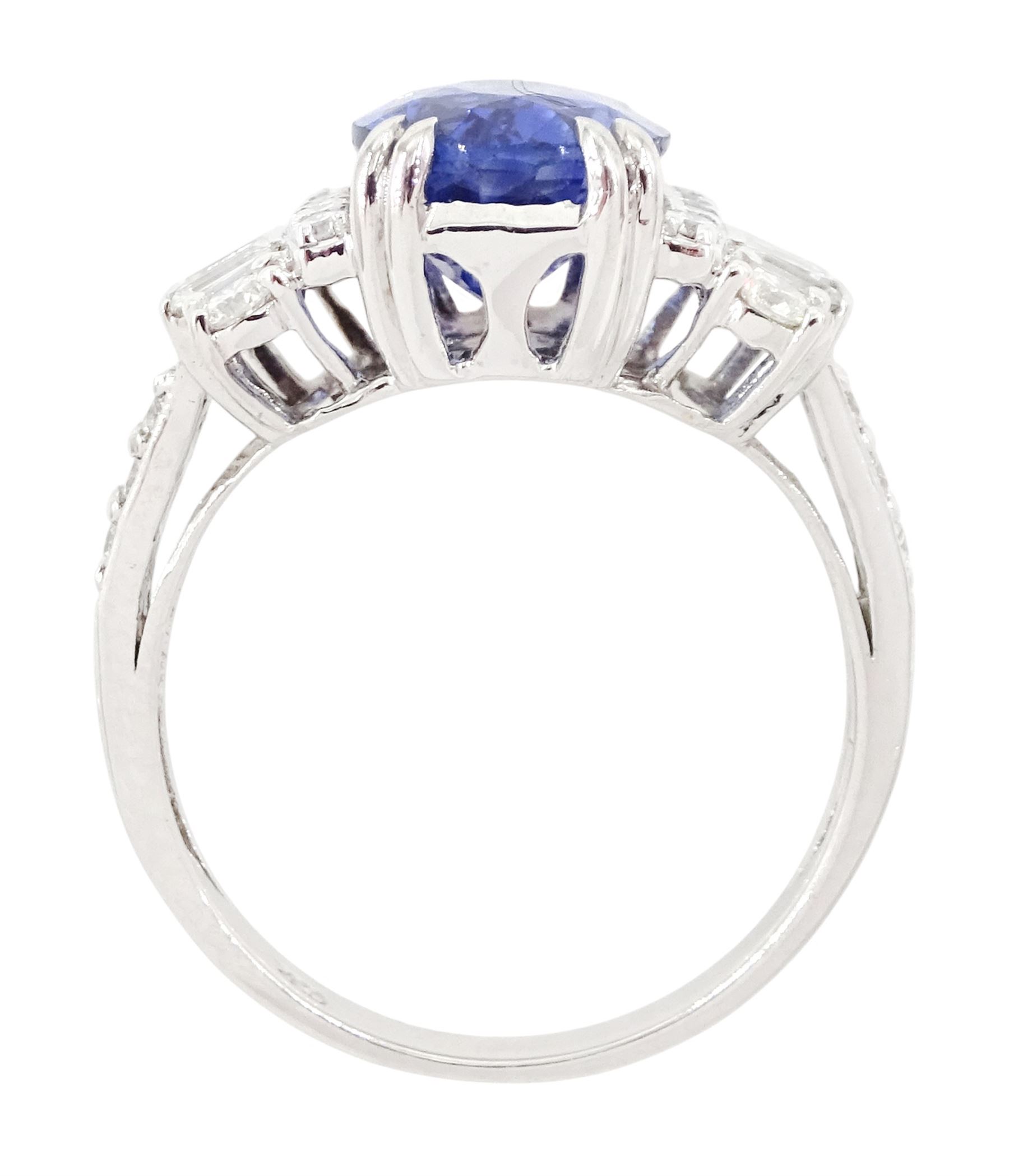18ct white gold Ceylon sapphire and diamond dress ring, single oval cut sapphire of 4.65 carat, either side set with round brilliant cut and baguette cut diamonds and diamond set shoulders, stamped 750, total diamond weight 0.77 carat, with World Gemological Institute report
