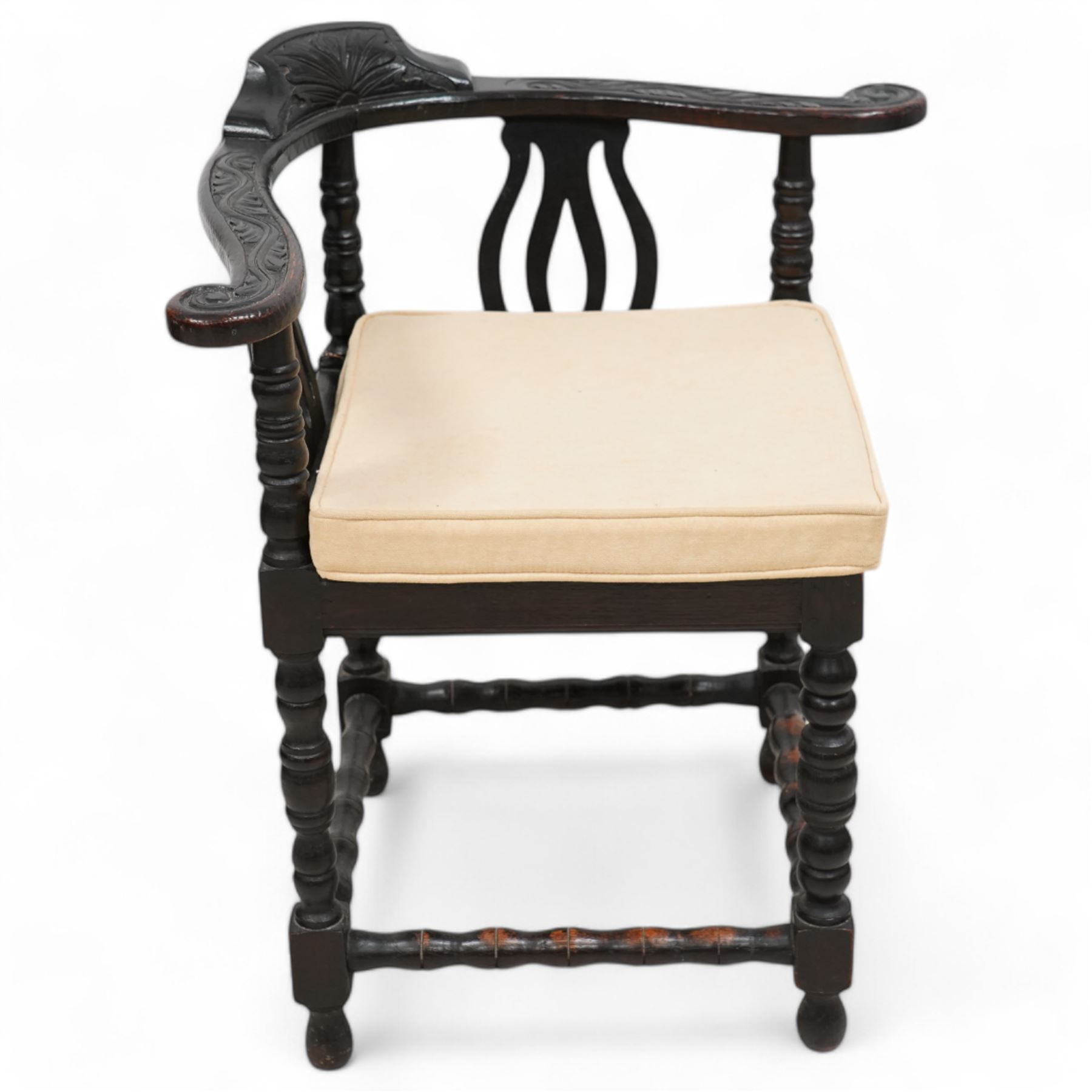 Victorian carved oak corner chair, shaped arms carved with trailing leafy branches, pierced splats over panelled seat, on bobbin turned supports and stretcher