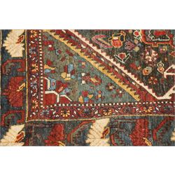 Antique Persian Qashqai dark indigo ground tribal rug, the busy field decorated with a geometric triple pole medallion surrounded by numerous stylised plant motifs with contrasting cyan spandrels, the multiple guard bands woven with stylised palmettes and foliage