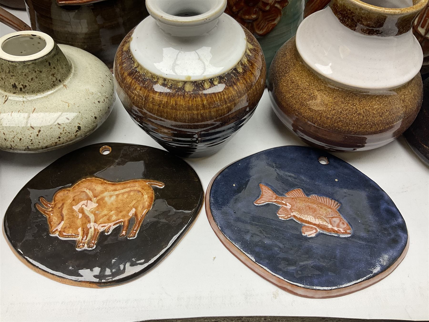 Wold studio pottery tankards, in various colours and relief decoration together with other studio items including vases, jugs and pots 