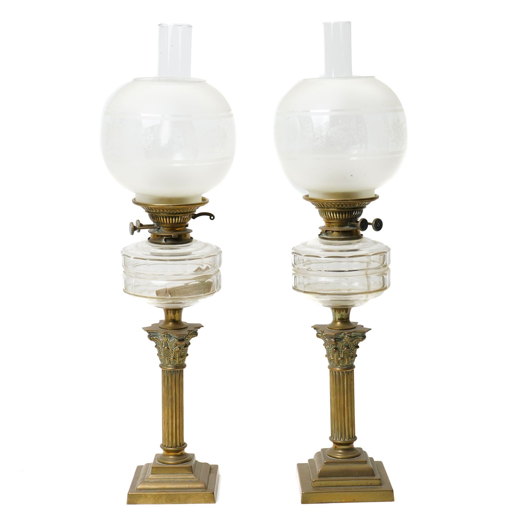 Pair of Victorian table oil lamps with clear glass reservoirs on brass Corinthian columns and stepped square bases with chimneys and etched glass shades H71cm overall