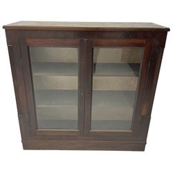 Edwardian mahogany enclosed bookcase, fitted with two glazed doors enclosing two shelves, flanked by reeded uprights, on skirted base