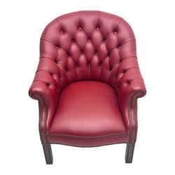 Kingsgate - contemporary 'Devon' bucket armchair, upholstered in red leather with buttoned backrest, rolled arms and brass stud detailing, raised on four dark wood supports with vertical carving