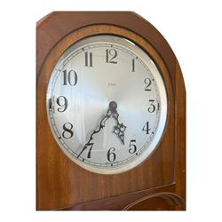 English- Art deco mahogany 8-day longcase clock, with an arched top and fill length fully glazed door beneath, on a short plinth with bracket feet, three train chain driven movement with visible stainless steel cased weights and pendulum, silvered dial with Arabic numerals, minute track and pierced steel hands, quarter chiming movement with  Westminster/ Whittington/ strike/silent selection.
