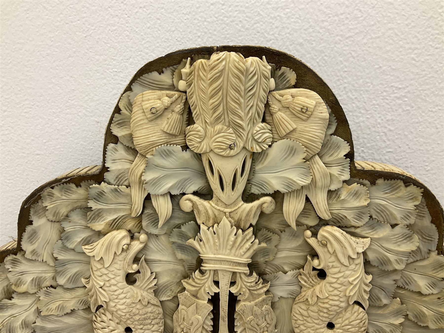 Pair 19th century French Dieppe bone and ivory wall mirrors, the oval bevelled mirror plates within rectangular frames with shaped tops, profusely decorated with ivory leaves, further detailed with carved bone armorial type crest inscribed 'SGOTORVM', putti, fish and mask heads, H81cm W48cm
