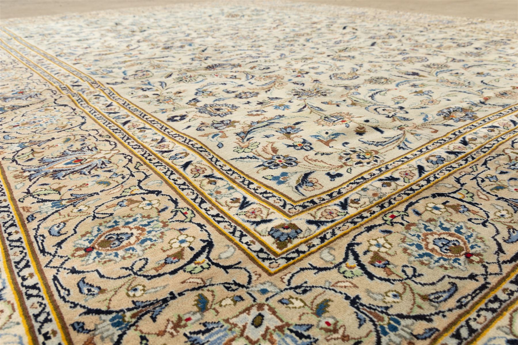 Central Persian Kashan hand-knotted rug, ivory field intricately decorated with an all-over design of scrolling vines, palmettes, and stylized lotus motifs in shades of soft blue, pale gold, and indigo within floral borders