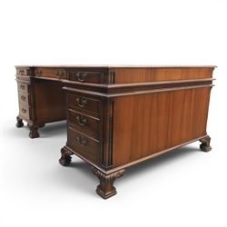 George III style large mahogany reverse breakfront partners desk, red tooled leather writing surfaces crossbanded and moulded edges, flanked by ring-turned cluster columns three frieze drawers with brass swan neck handles, raised on large pedestals with faux drawer fronted cupboard and three graduated drawers, supported on carved ogee feet decorated with C-scrolled and acanthus leaves