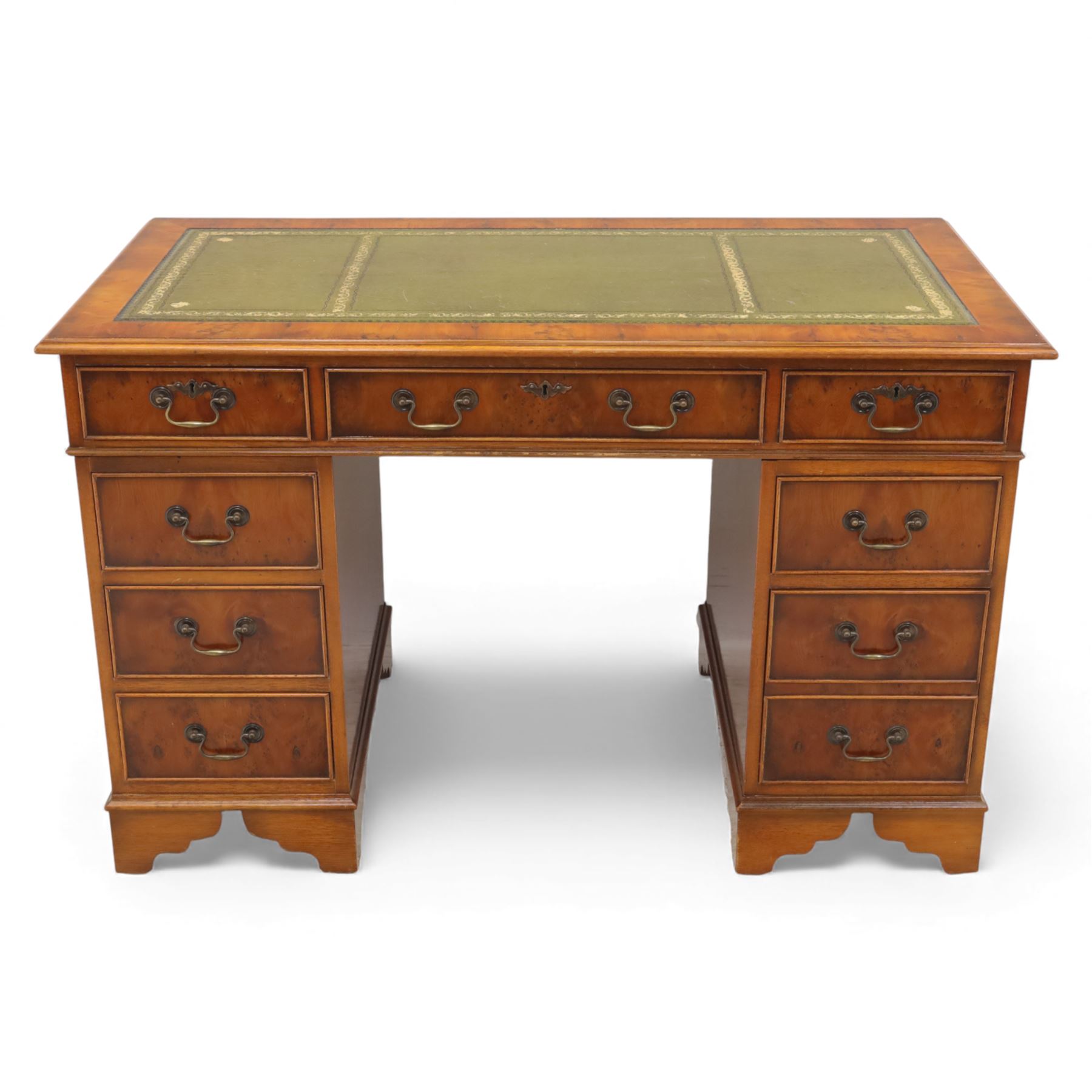 Late 20th century yew wood nine drawer writing desk, rectangular top inset with gilt-tooled green leather, above an arrangement of nine drawers with brass swan-neck handles, raised on bracket feet