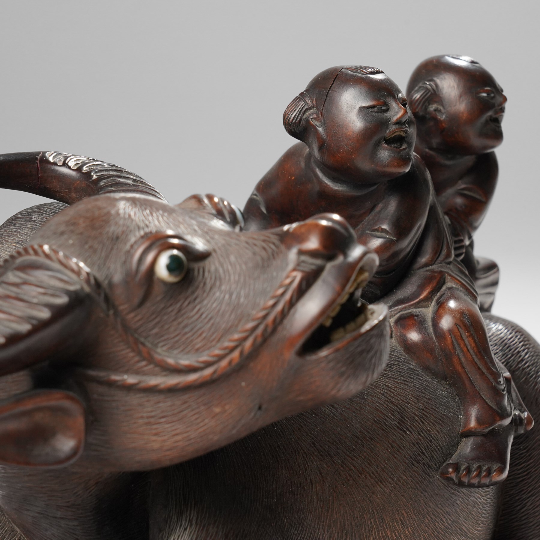 Early 20th century Chinese carved hardwood figural group of two boys on the back of a water buffalo on wooden stand W37cm