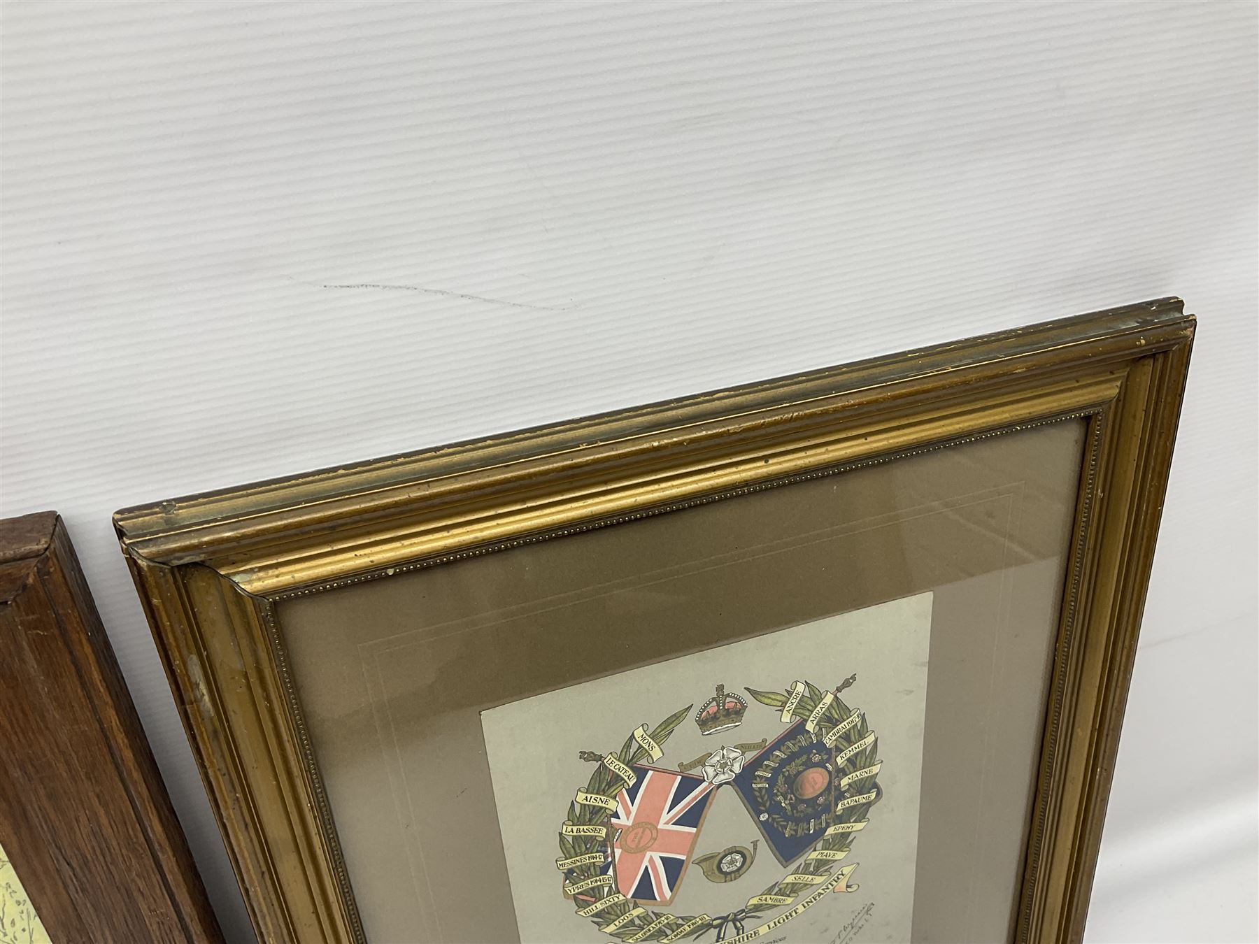 WW1 chromolithograph print of a battle scene with French and German soldiers in a wood, entitled 'De Wereldoorlog 1914-18 Slag Van Houthulst' 35 x 49cm, oak frame; and a framed WW1 regimental testimonial to 49744 Pte. E. Jagger KOYLI, gilt frame (2)