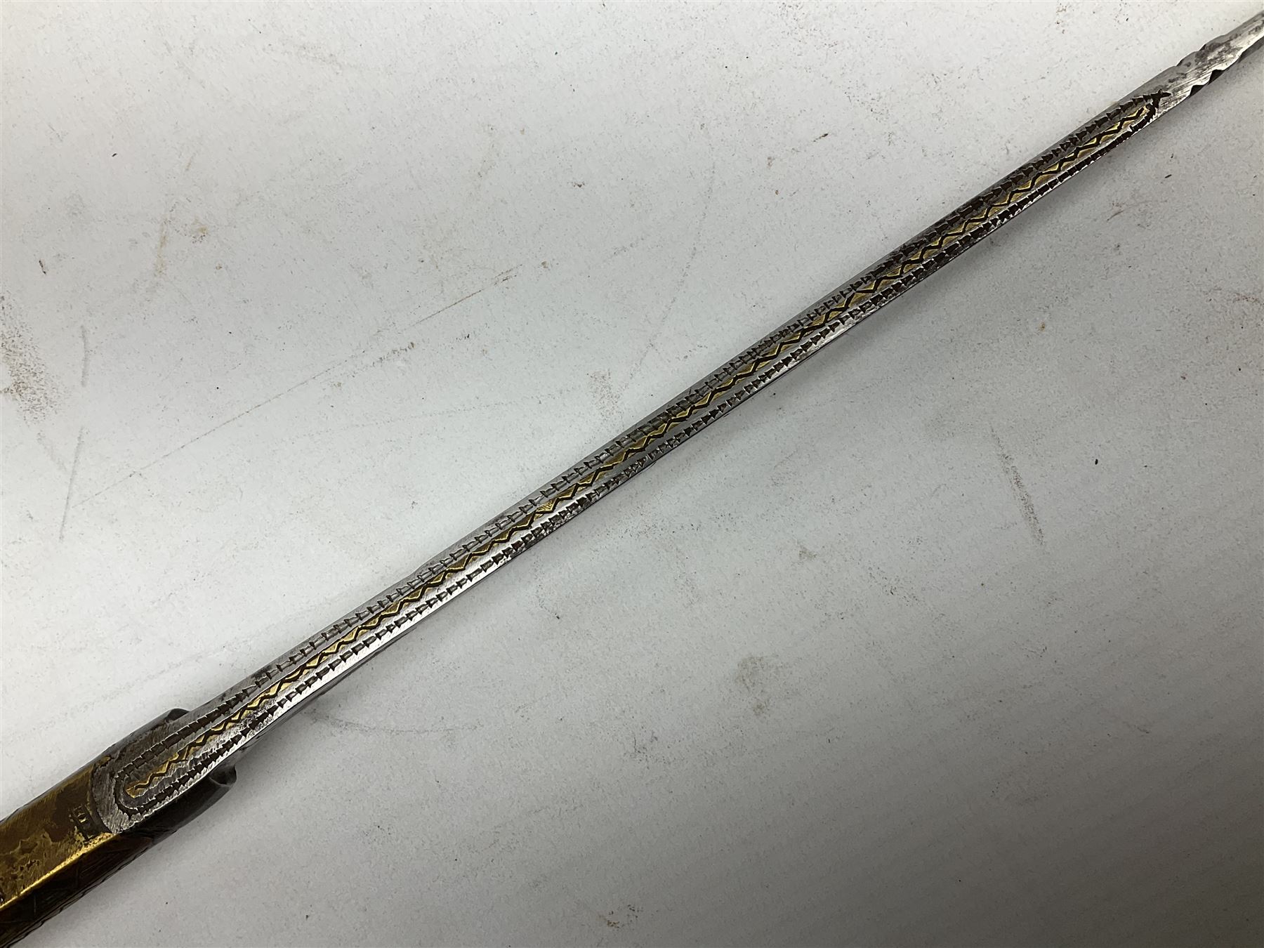 19th century Algerian Flyssa long knife, the 34cm single edged pointed decorative blade inset with yellow metal, chased brass grip with pommel as the snout of a stylised animal and carved hardwood scabbard L45cm overall