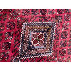 Persian Joshaghan crimson ground rug, stepped lozenge medallion surrounded by repeating foliate lozenge motifs, the border decorated with stylised plant motifs, within geometric guard stripes 