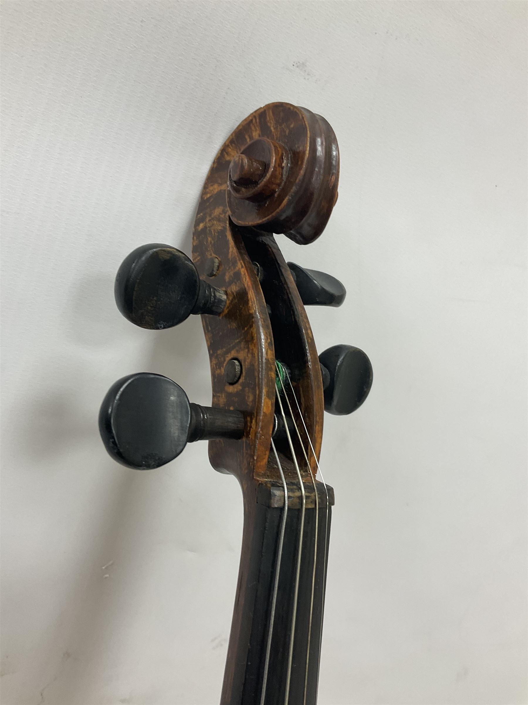 Copy of a full size Stradivarius violin, with an ebonised fretboard, tailpiece and tuning pegs, with a polished chin rest  Length 60cm