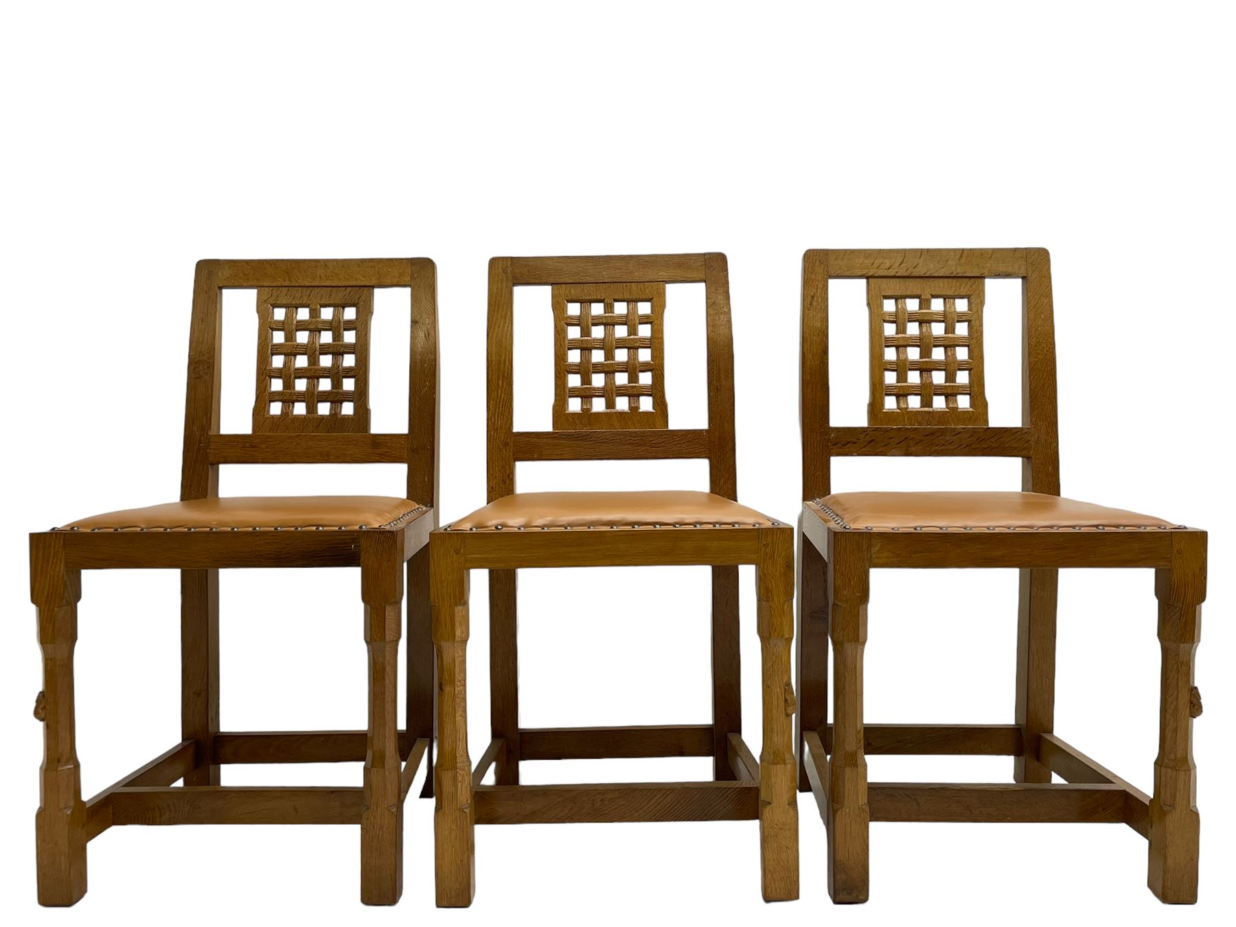 Rabbitman - set of six (4+2) oak dining chairs, carved and pierced lattice back, tan leather upholstered seat with stud band, on octagonal supports united by H-stretchers, carved with rabbit signature, by Peter Heap, Wetwang 