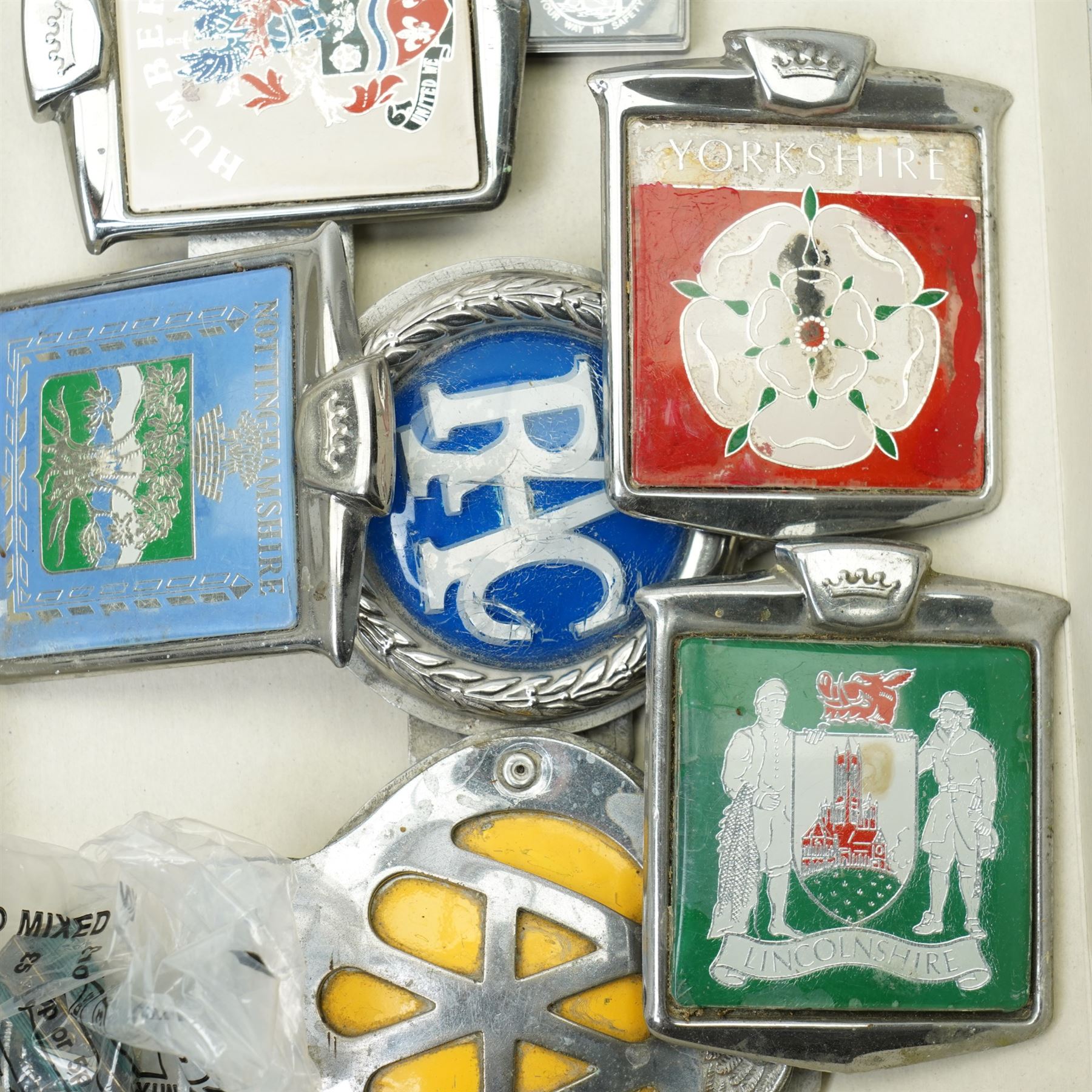 Collection of vintage car badges including AA, RAC, county badges, VW cufflinks etc