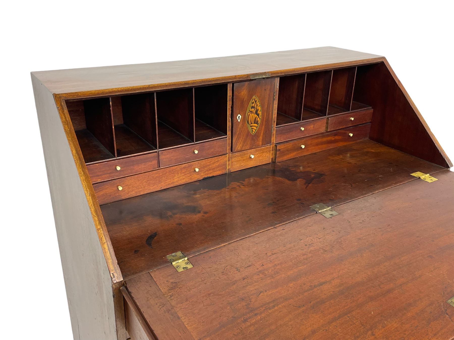 George III mahogany bureau, the fall-front banded and with boxwood stringing, enclosing fitted interior with pigeonholes and drawers surrounding a central cupboard with inlaid shell motif, the base with four graduating cock-beaded drawers, each with pressed brass handle plates with central lion masks and ivory escutcheons, on shaped bracket feet
This item has been registered for sale under Section 10 of the APHA Ivory Act