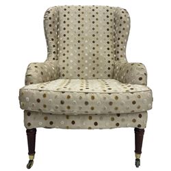 Victorian design wingback armchair, sprung seat with loose cushion upholstered in polka dot fabric, on turned supports with castors