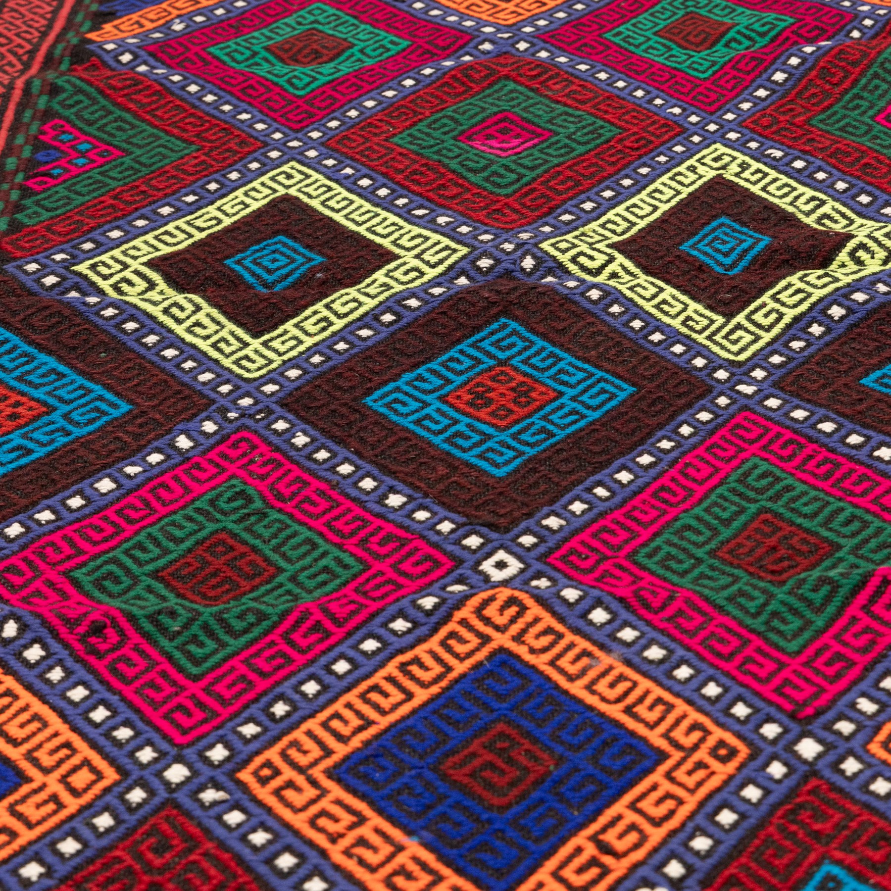 Afghan kilim runner rug, the field decorated with geometric patterned concentric lozenges in multicolours, the contrasting guard stripes with repeating chevron design
