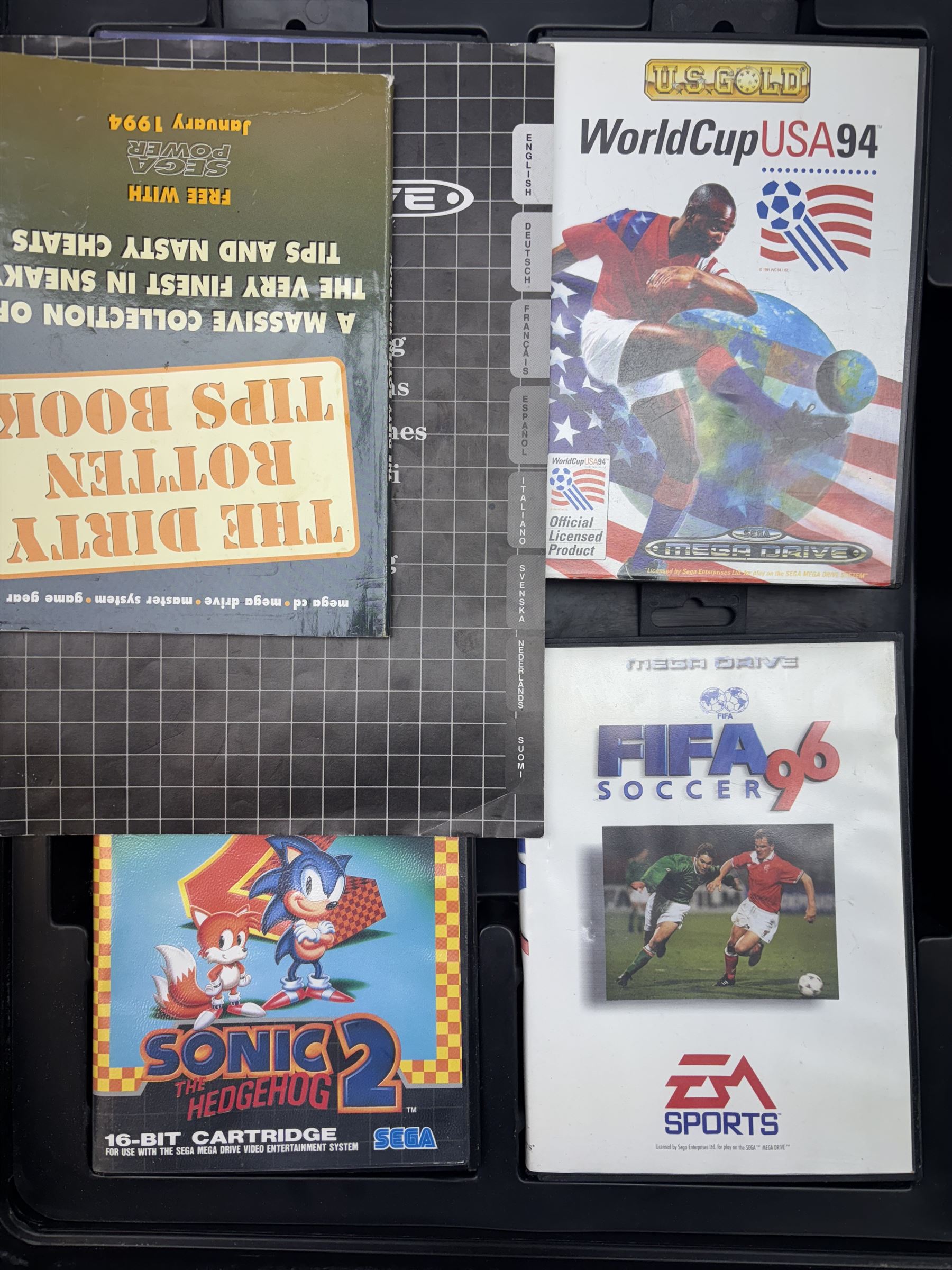 16-Bit Sega Mega Drive console with two controllers and four games, comprising Fifa 96, Sonic The Hedgehog 2, Sonic The Hedgehog Pinball and World Cup USA 94, contained within fitted plastic carrycase with instruction manual and cheats book