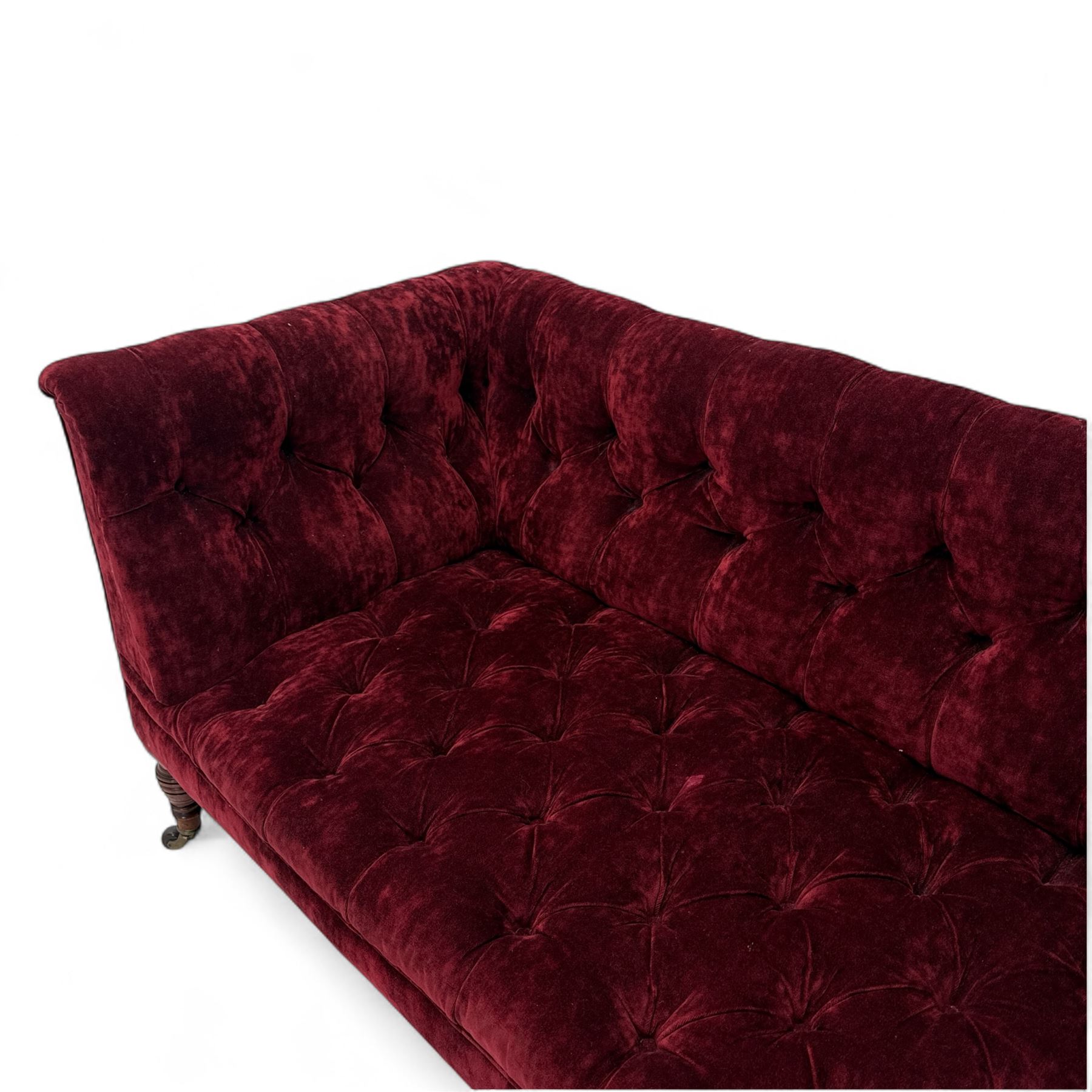 Late Victorian upholstered chaise longue in buttoned red velvet, shaped backrest, on turned walnut legs 