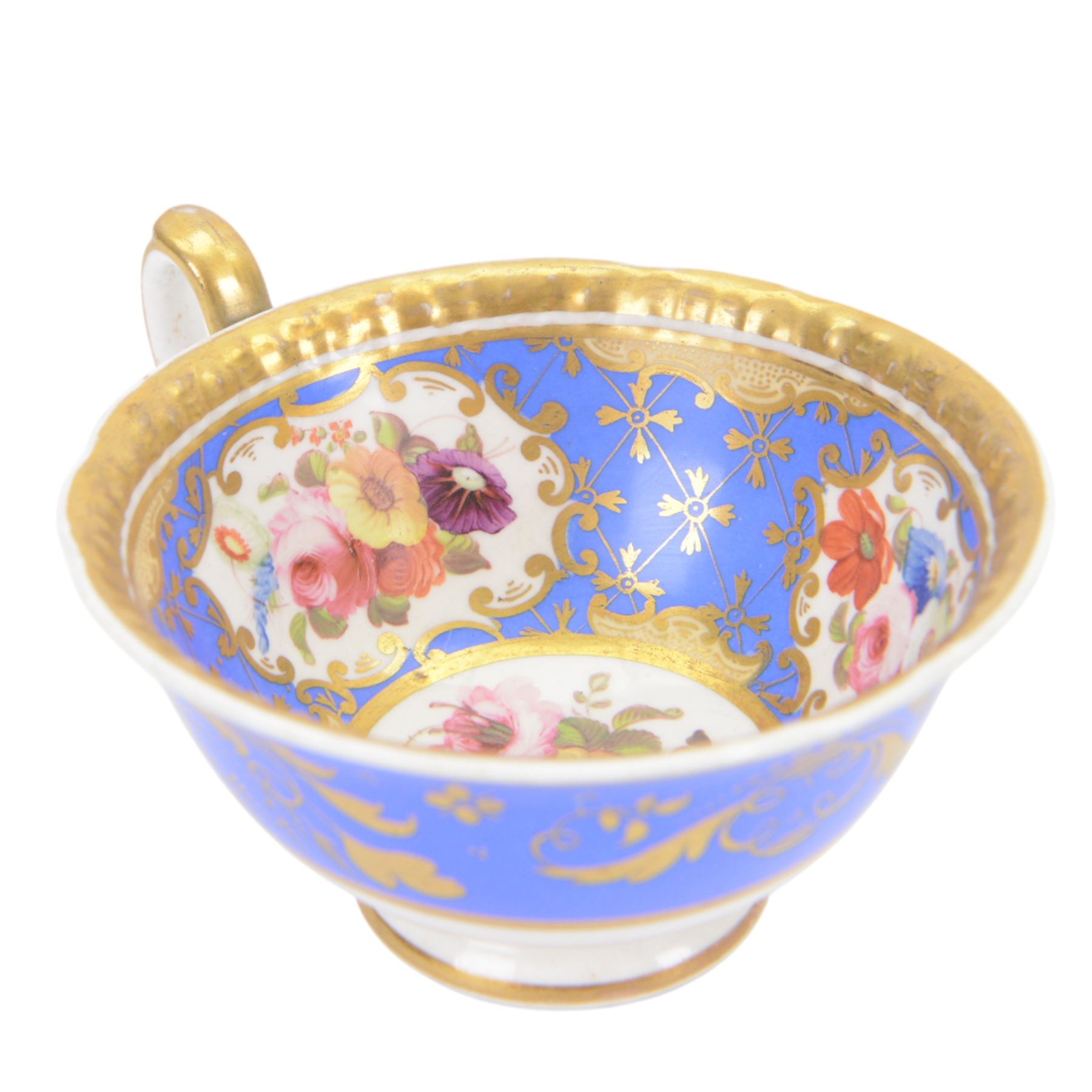 H&R Daniel trio, coffee cup, teacup and a saucer, circa 1825, Gadroon shape with D handle, painted with reserves of fine foliate sprays against a blue ground with gilt trellis detail, coffee cup including handle H8.5cm, saucer D14cm