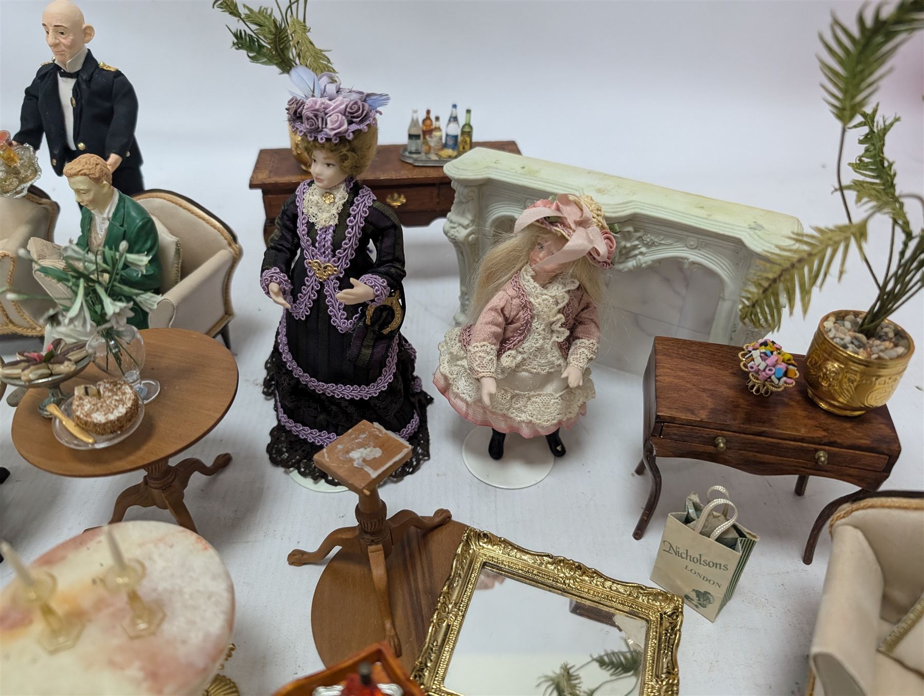 Dolls house furniture, including sofa, chairs, foot stools, fireplace, sideboards, five figures, mirrors, paintings and accessories