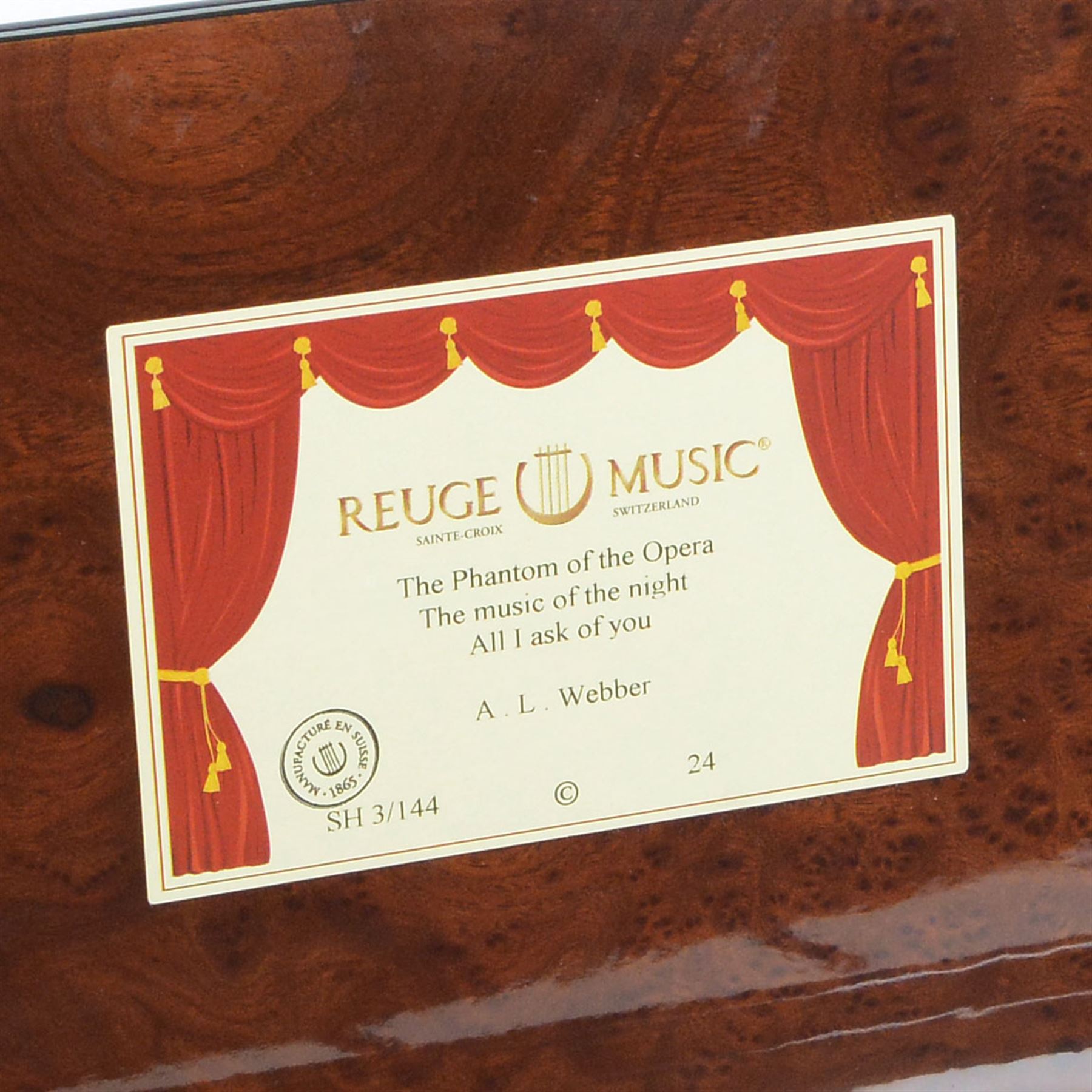 Reuge Sainte-Croix- 21st century Swiss musical box with a highly polished lacquered finish, inlaid and ebonised case with a glazed internal viewing lid, polished steel 144 teeth two-part comb playing three arias from The Phantom of the Opera by Lloyd Webber, with tune indicator and tune sheet.