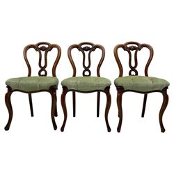 Set of six carved Victorian walnut balloon back dining chairs, button upholstered in green velvet fabric, back with foliate carved decoration supported on scroll form legs 