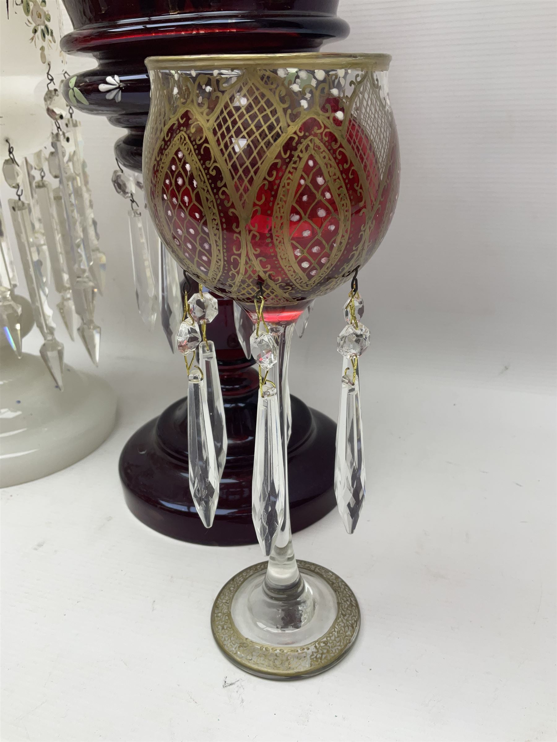 Bohemian red glass lustre, painted with stylised floral and foliate decoration, together with a milk glass example and two bohemian goblets converted to lustres 