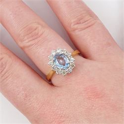18ct gold aquamarine and diamond cluster ring, oval cut aquamarine of approx 0.80 carat, with round brilliant cut diamond surround, London 2022, total diamond weight approx 0.55 carat