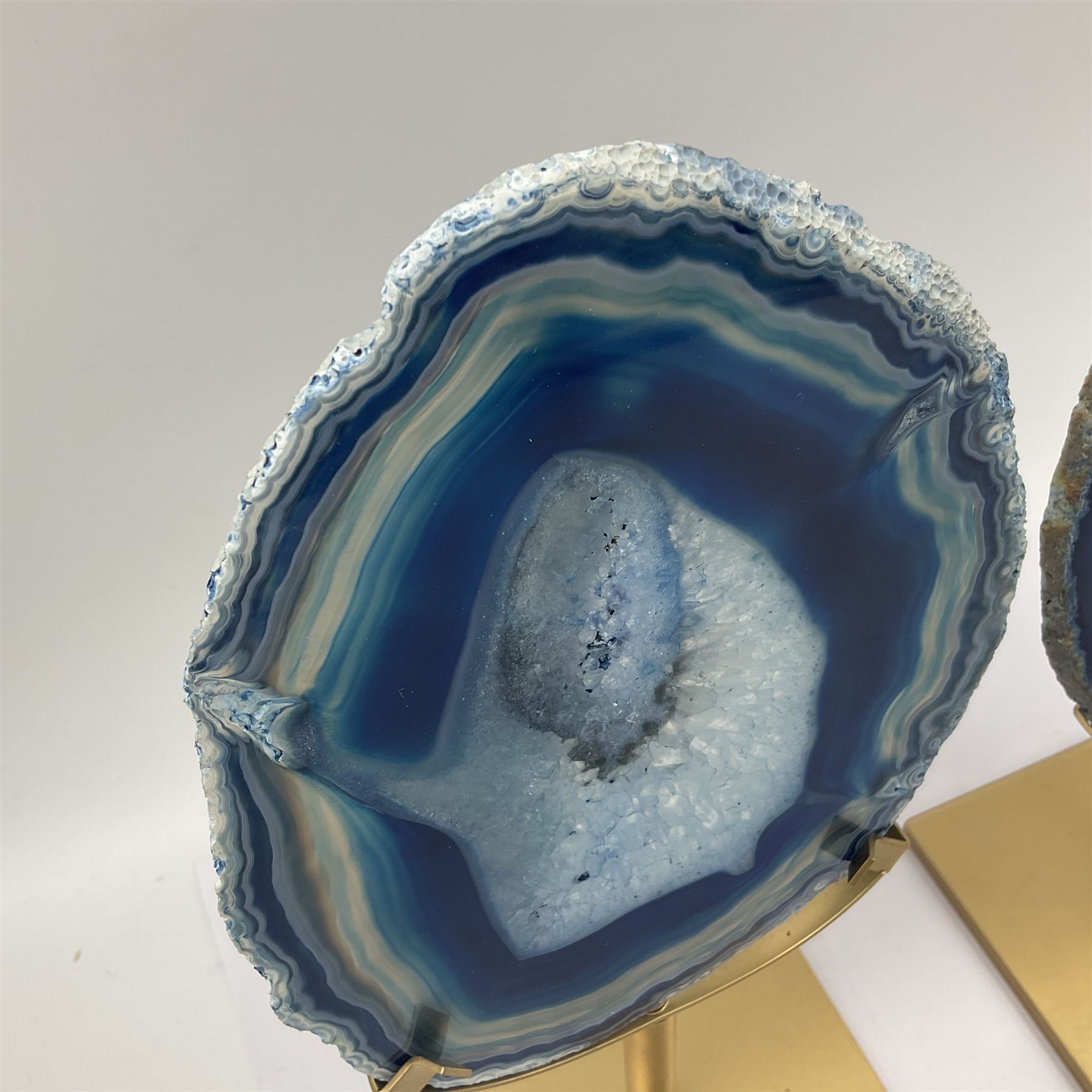 Pair of blue agate slices, polished with rough edges raised upon gilt metal stands, H22cm