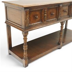 Titchmarsh & Goodwin - Tudor oak dresser base, three drawers flanked by foliate carving and carved wooden knobs, on turned and carved supports, united by a full length undertier