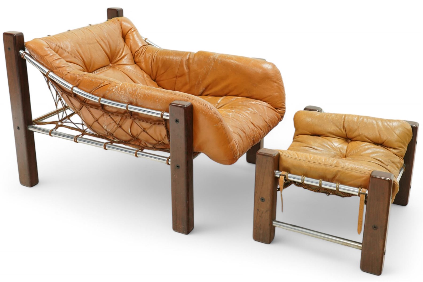Jean Gillon (Romanian/Brazilian 1919-2007): 'Amazonas' easy chair, mahogany framed with slung leather upholstered cushions, together with matching footstool