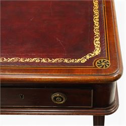 Regency inlaid mahogany and brass mounted library table, the rectangular top inset with gilt tooled burgundy leather writing surface, enclosed by  crossbanding and boxwood stringing with roundel corner motifs, above three cock-beaded frieze drawers to either side fitted with brass ring handles and brass escutcheons, the end friezes centred by applied brass foliate mounts, raised on twin reeded column supports over rectangular platform ends, united by a ring-turned stretcher, the reeded sabre legs terminating in brass caps and castors, one drawer bearing ivorine label 'Spillman & Co., St Martins Lane, London'