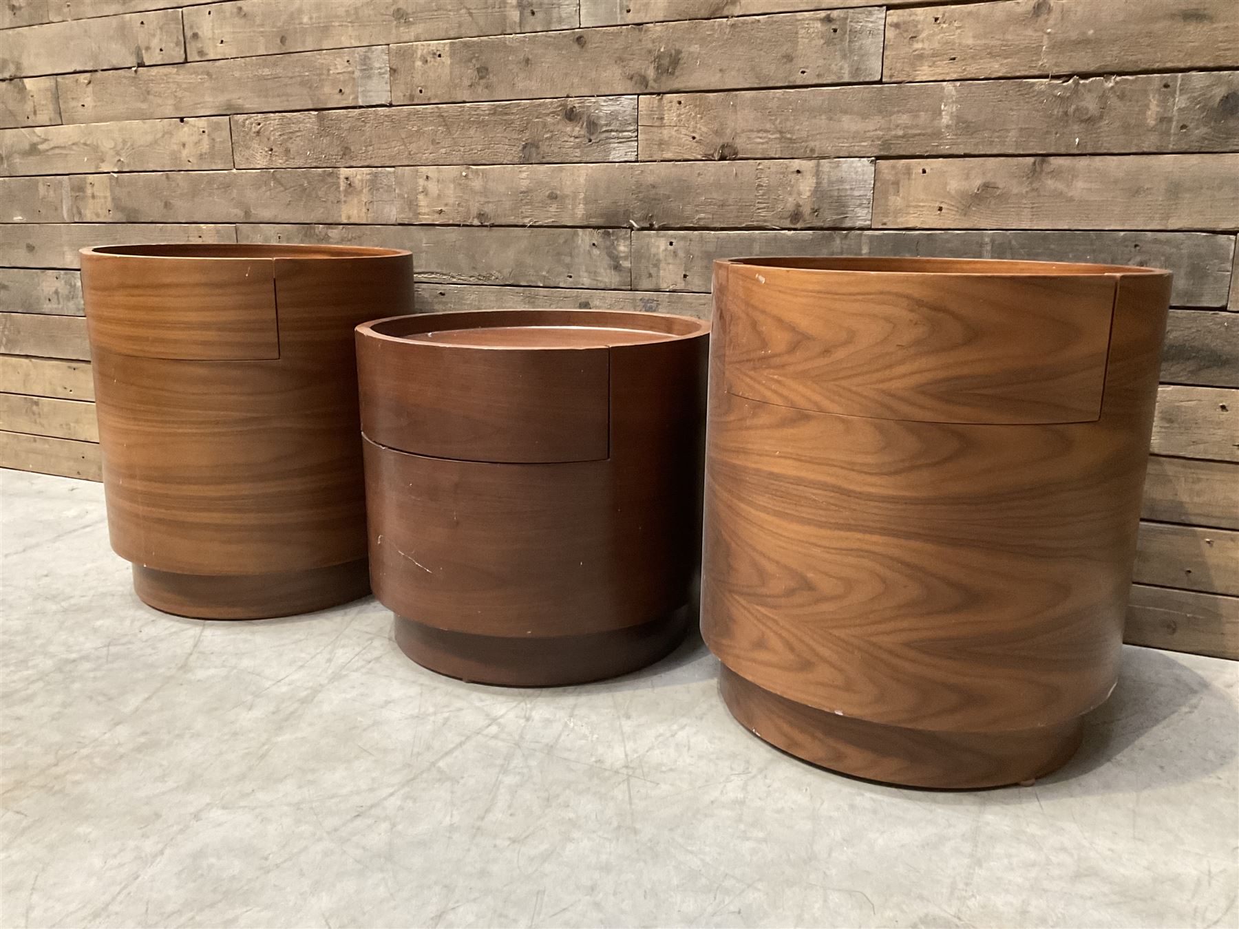 Three walnut circular barrel shaped lamp tables, fitted with single drawer (lower table D53cm, H49cm)