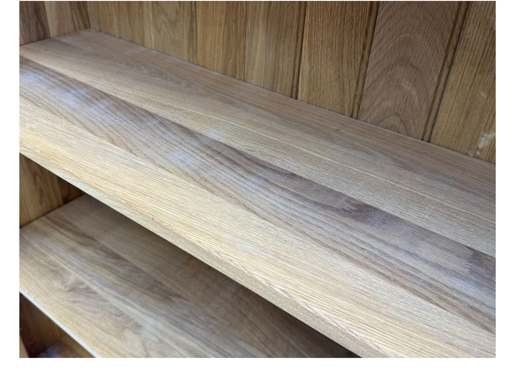 Contemporary light oak open bookcase, rectangular form with projecting top, fitted with five adjustable shelves, on a straight plinth base