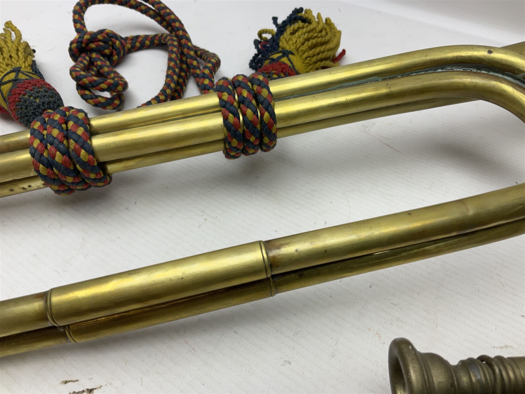 Two military brass bugles by Mayers and Harrison Ltd. Manchester each with crows foot mark and dated 1966; both with multi-coloured cord and tassels, longest 52.5cm (2)