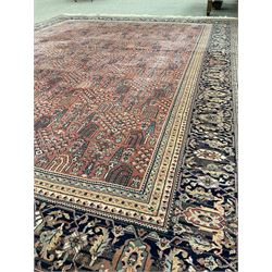Large Persian design red ground carpet, the field decorated with repeating tree of life design, multi-band border decorated with stylised flower heads