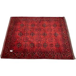 Afghan red ground rug, decorated all over with plant and flower head motifs, repeating border
