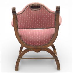 Late Victorian oak x-frame armchair, upholstered padded back and seat covered in pink patterned fabric with close studded borders, shaped downswept arms with scroll terminals, raised on curved x-frame supports with moulded scroll feet