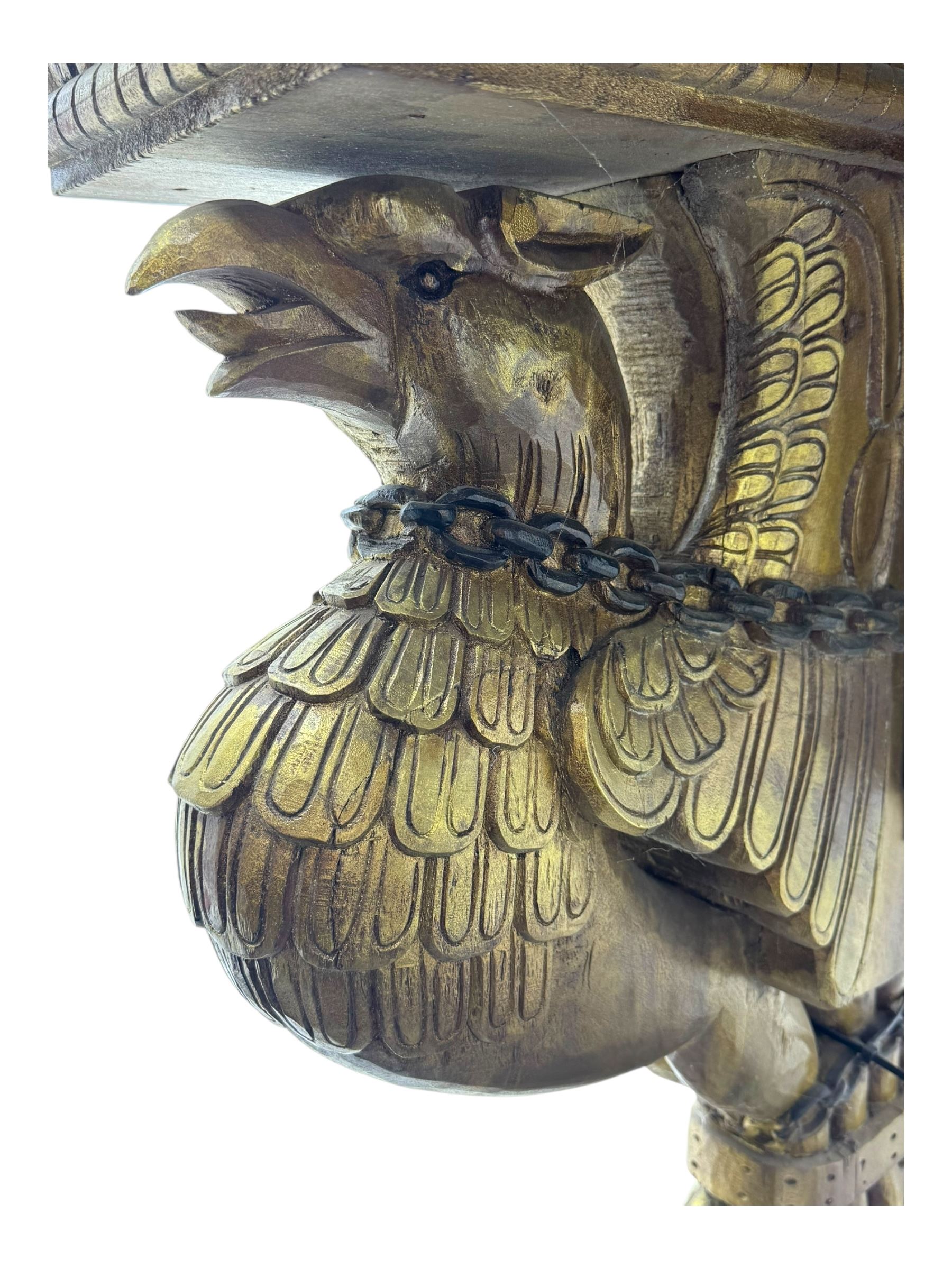 19th century Renaissance Revival carved and giltwood centre table, the rectangular top with gadrooned edge and carved frieze of repeating arched motifs with stylised scrolls, supported by a pair of carved winged griffin supports restrained by a central chained figure, on stepped rectangular bases united by carved stretcher