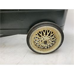 Mid 20th century pressed steel pedal car, the body painted in dark green fitted with pretend radiator to the bonnet, with spoked wheels and rubber tyres, the interior with pedals and steering wheel, L70cm
