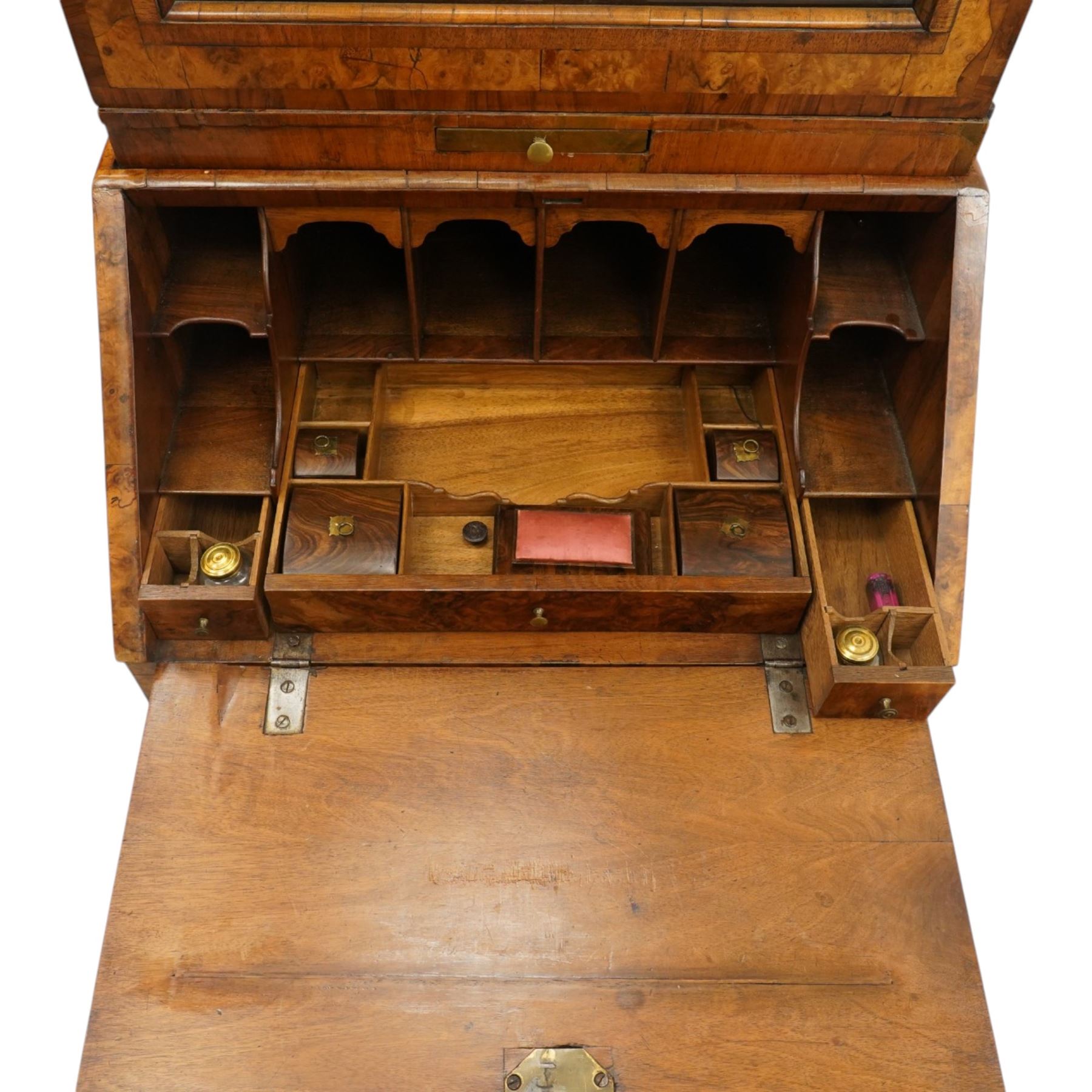 Quality George I figured and burr walnut bureau-cabinet of unusually small proportions, the projecting cavetto cornice over a glazed and banded door enclosing four adjustable shelves, with a candle slide below, the book-matched and banded veneer fall-front enclosing a fitted interior with pigeonholes, correspondence drawers and original trinket boxes and inkwells, over two pull-out stays and four graduating long drawers with banded facias and pressed brass escutcheons and pull handles, lower moulded edge on bracket feet
Provenance: purchased Sotherby's 1977