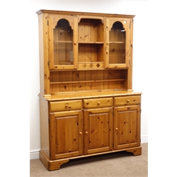  Ducal pine dresser, two glazed doors with central shelves, above three drawers and three cupboards, on shaped bracket supports, W132cm, H190cm, D45cm Ducal pine sideboard with three drawers above three cupboards, on shaped bracket supports, W132cm, H87cm, D45cm  