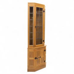 Mouseman - oak standing corner cabinet with leaded glass top above a panelled base, iron s...