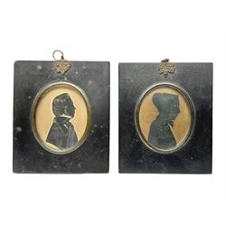 Two early 19th century silhouettes, the first example depicting the side profile of s gentleman, with gilt detailing, stamped J.I Manginn verso, the second example depicting the side profile of a female in a bonnet, indistinctly signed verso, both within laquered wooden frames, frame H13cm