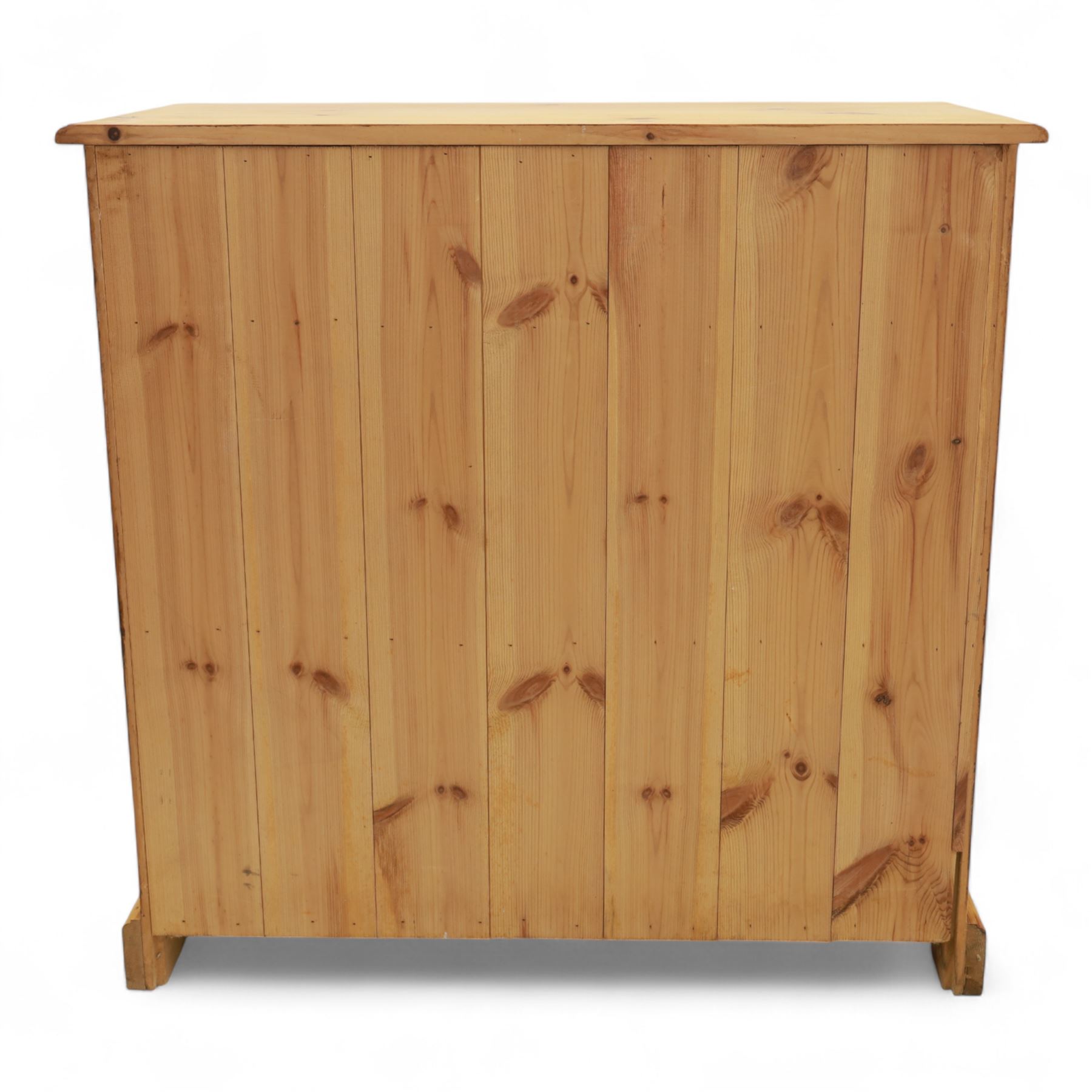 Contemporary pine storage cabinet, the rectangular top with rounded corners, over twin drawers and panelled cupboard doors, fitted with turned knob handles, plinth base