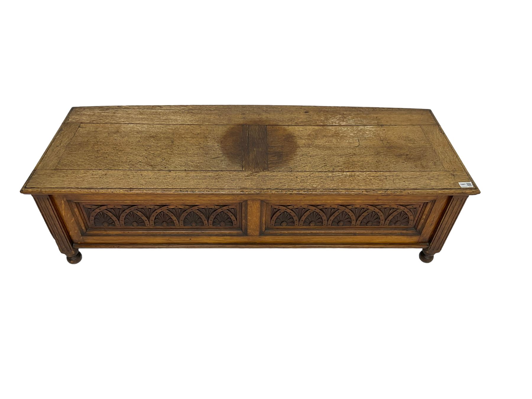 Early 20th century oak ‘bay window’ shaped blanket chest or coffer, hinged top, the front with two lunette carved panels flanked by fluted uprights, on turned feet